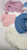 Collection of doll clothing accessories, including a blue denim hat with a white daisy, a pink cardigan, a blue jacket with faux-fur trim, undergarments, and a white faux-fur collar. The collection is for 18-inch dolls.