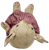 This approximately 9-inch-tall seated pig is made from sewn canvas and features the rustic, handcrafted appearance characteristic of primitive folk-art figures. The pig has a natural canvas-colored body with hand-painted facial features, including expressive black eyes, rosy cheeks, and a reddish-pink snout.