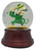 PJML Vintage 1999 PJML Notre Dame Musical Snow Globe – Fighting Irish Leprechaun, glass snow globe featuring a green-clad Fighting Irish leprechaun in a shamrock hat, with blue confetti and a dark wood-tone base