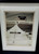 University of Notre Dame Notre Dame Fighting Irish Stadium Black & White Framed Photo – 13" x 16", black-and-white stadium photograph showing empty bleachers and a central stairway leading to the Notre Dame scoreboard, displayed in a white mat and black frame.