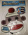 Sock Monkey Talking Sock Monkey Moving Mouth Mask, plush sock monkey mask with buttons for eyes and a mouth that moves when triggered, featuring a red pom-pom hat and instructional label.