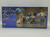 Hasegawa Models Racing Figure Set, plastic model kit featuring detailed racing figures including a woman with an umbrella, a race car driver in a racing suit, and a standing figure in racing attire.