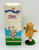 AVON Somersaults Zippy Mini Doll, small plastic doll of a character with a waffle body, wearing pink shoes, standing on green grass.
