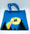 E.T. Vintage 1982 E.T. Canvas Tote, a blue canvas tote bag featuring a design with E.T. and a silhouette of a child riding a bicycle against a large moon with colorful trails and trees.