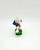 Smurfs Vintage PEYO 4.0204 Skateboard Smurf (Leaf Variant) PVC Figure, a small figurine of a Smurf character riding a skateboard with a green leaf design.