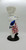 Pillsbury Doughboy 'Baked to Perfection' Porcelain Doll, a collectible porcelain doll depicting the Pillsbury Doughboy dressed as a chef with a white chef's hat, blue oven mitt, and red and white checkered apron, standing on a black base.