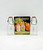 J.S.N.Y. Vintage 1974 Early American Dairy Bottle Salt & Pepper Set, transparent glass salt and pepper shakers with red caps and wire closures, displayed with vintage packaging featuring images of similar bottles and fresh produce.