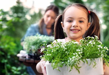 young-girl-holding-alyssum-pot.jpeg