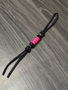 Black Paracord Shorty Knife Nub with Black Reverse Crowns, Black Faceted Beads, and Pink Metal Bead Black Paracord Shorty Knife Nub with Black Reverse Crowns, Black Faceted Beads, and Pink Metal Bead