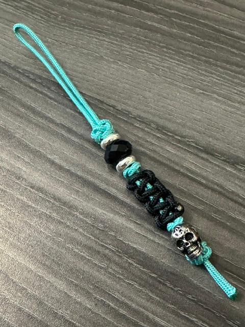 Turquoise Mini Cord Lanyard with Black Cobra Wrap and Engraved Stainless Skull Accented by Silver Spacers and Black Faceted Beads