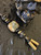 Gold Flake and Shredded Money Resin Knife Nub Lanyard On Black & Gold Paracord