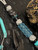 Silver Carbon Fiber, Black G10, and Black Web Turquoise Split Bead Lanyard with Arctic White Paracord, Turquoise & Black Diamond Cobra Wrap, Black Metal Skull, and Turquoise Spacers