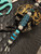 Silver Carbon Fiber, Black G10, and Black Web Turquoise Split Bead Lanyard with Arctic White Paracord, Turquoise & Black Diamond Cobra Wrap, Black Metal Skull, and Turquoise Spacers