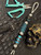 Silver Carbon Fiber, Black G10, and Black Web Turquoise Split Bead Lanyard with Arctic White Paracord, Turquoise & Black Diamond Cobra Wrap, Black Metal Skull, and Turquoise Spacers