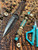 Custom Sculpted Richlite Micarta Bead with Turquoise Blue and White Liners on Matching Camo 550 Cord Accented by Brass Winged Helmet and Two-Tone Mini Cord Cobra Wrap