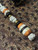 Custom Split Bead Knife Lanyard with Gold Web Tru-Stone, Koa Wood, Ebony, and Brass Spacers on White with Black Spec Paracord