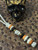 Custom Split Bead Knife Lanyard with Gold Web Tru-Stone, Koa Wood, Ebony, and Brass Spacers on White with Black Spec Paracord