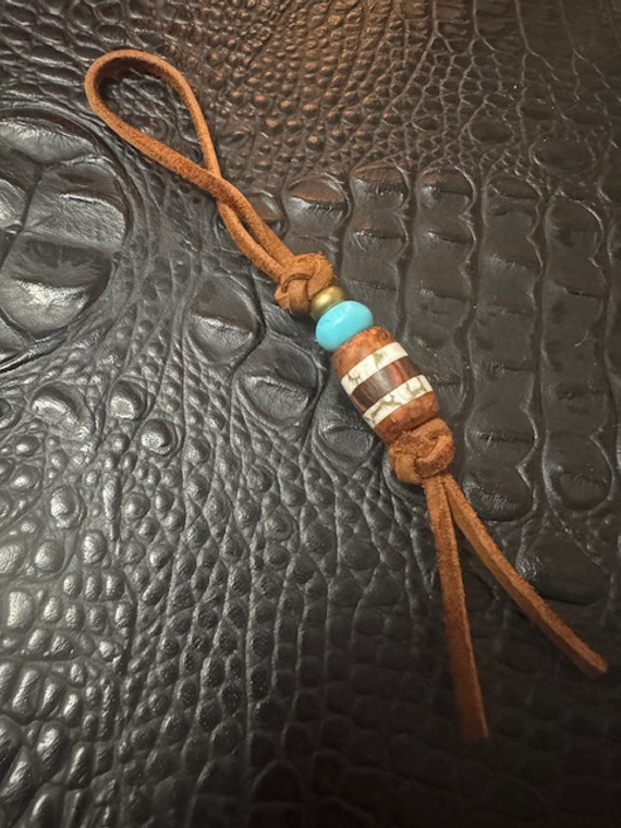 Leather Shorty Knife Nub with Amboyna Burl, Gold Web Tru-Stone, and Ironwood Split Bead Accented by Turquoise & Brass Leather Shorty Knife Nub with Amboyna Burl, Gold Web Tru-Stone, and Ironwood Split Bead Accented by Turquoise & Brass