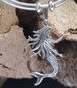 Close up of detailed sterling silver dancing mermaid pendant with flowing hair and scaled tail — Florida artisan jewelry