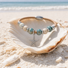 Sterling silver starfish cork bracelet with ceramic beads styled in a seashell on the beach - Crabby Mermaid