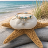 Sterling silver starfish cork bracelet with ceramic beads styled on driftwood with a starfish and ocean view — Crabby Mermaid
