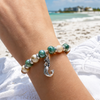 Close-up of cork bracelet with ceramic beads and sterling silver mermaid charm worn on wrist at the beach - Crabby Mermaid