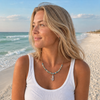 Close-up of woman wearing sterling silver mermaid cork necklace on a Florida beach — Crabby Mermaid