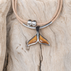 Koa wood whale tail necklace on cork cord hanging from driftwood on a Florida beach - Crabby Mermaid