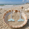 Larimar whale tail drop earrings in sterling silver in seashell on Florida beach