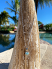 Larimar heart necklace displayed on palm tree in Florida sunshine — genuine Dominican Republic Larimar on sterling silver chain