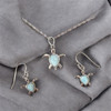 Larimar sea turtle pendant necklace and matching hook earrings in sterling silver on gray fabric — hand assembled by Crabby Mermaid