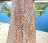 Tanzanite and blue opal crab pendant necklace in sterling silver displayed outdoors ‚Äî Crabby Mermaid