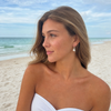 Woman wearing freshwater pearl dangling earrings on a Florida beach — Crabby Mermaid