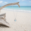 Larimar crab necklace with cubic zirconia in sterling silver hanging from driftwood on Florida Gulf Coast beach - genuine Dominican Republic Larimar - Crabby Mermaid