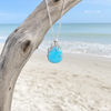 Larimar octopus necklace in sterling silver hanging from driftwood on Florida Gulf Coast beach — genuine Dominican Republic Larimar — Crabby Mermaid