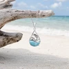 Larimar dolphin teardrop necklace in sterling silver hanging from driftwood on Florida Gulf Coast beach — genuine Dominican Republic Larimar — Crabby Mermaid