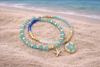 Mint gold beaded bracelet set worn on wrist showing starfish and sand dollar charms - beach jewelry - Crabby Mermaid