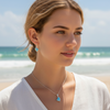 Larimar heart necklace and earring set in sterling silver worn by model at beach — genuine Dominican Republic Larimar — Crabby Mermaid
