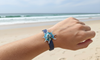 Blue abalone conch shell magnetic bracelet worn on wrist at the beach - coastal statement jewelry - Crabby Mermaid