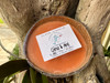 Citrus and mint coconut shell candle resting in tree trunk outdoors — natural soy coconut wax candle — Crabby Mermaid