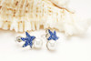 Sterling silver pearl sapphire starfish earrings displayed on seashell - coastal ocean jewelry gift handcrafted in Ireland - Crabby Mermaid