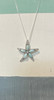 Larimar & Cubic Zirconia Starfish .925 Sterling Silver Necklace

This magnificent Larimar and Cubic Zirconia Starfish Necklace is sure to make a statement. The striking blue hues of the larimar stone are adorned with cubic zirconia for a dazzling look. The necklace hangs from a durable .925 Sterling Silver Chain, measuring 18 inches and Made in Italy.
The Larimar stone offers numerous benefits to the wearer. Not only does it provide relief from stress and calming emotions, but it also facilitates enlightenment across physical, mental, emotional, and spiritual planes. Moreover, the stone works to stimulate the heart, throat, third eye, and crown chakras, leading to inner wisdom and outer manifestation. Wearing larimar amplifies the wearer's emotional state to draw forth their innermost joy and unlock their own personal knowledge.