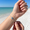 Larimar sea turtle adjustable bracelet in sterling silver worn on model's wrist on Florida Gulf Coast beach ‚Äî genuine Dominican Republic Larimar ‚Äî Crabby Mermaid