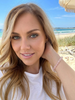 Woman wearing rose quartz gemstone beaded stretch bracelet at the beach — Crabby Mermaid