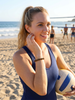 Woman wearing tiger eye gemstone beaded bracelet on the beach holding a volleyball — Crabby Mermaid