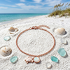 Rose gold plated white opal turtle sterling silver bracelet on white sand with seashells and sea glass — Florida Gulf Coast beach — Crabby Mermaid