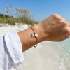 Rose gold plated white opal turtle sterling silver bracelet worn on wrist on Florida Gulf Coast beach - Crabby Mermaid