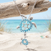 Sterling silver aqua crystal mother and baby sea turtle pendant hanging from driftwood on Florida Gulf Coast beach - handcrafted in Ireland - Crabby Mermaid