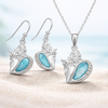 Larimar and cubic zirconia conch shell necklace and earring set in sterling silver on sand — hand assembled by Crabby Mermaid