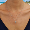 Sterling silver starfish necklace with aqua Swarovski crystals closeup on neckline at Florida beach - handcrafted in Ireland - Crabby Mermaid